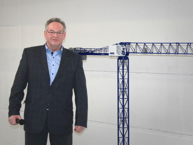 Herr Martin neben seinem Abschiedsgeschenk. Ein Modell des ersten eigenen Kran unter dem Label der AMS, der AK 150.8